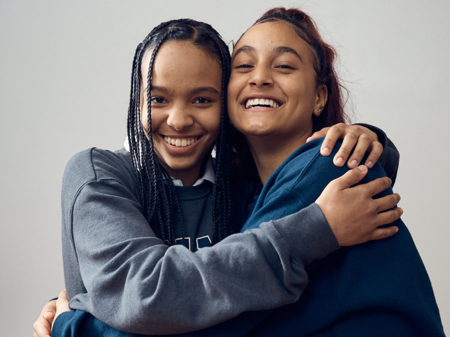 Photograph of two girls laughing and hugging