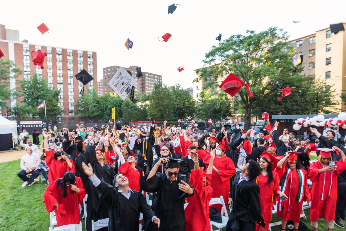 Photo of the 2021 high school graduating class throwing caps into the air